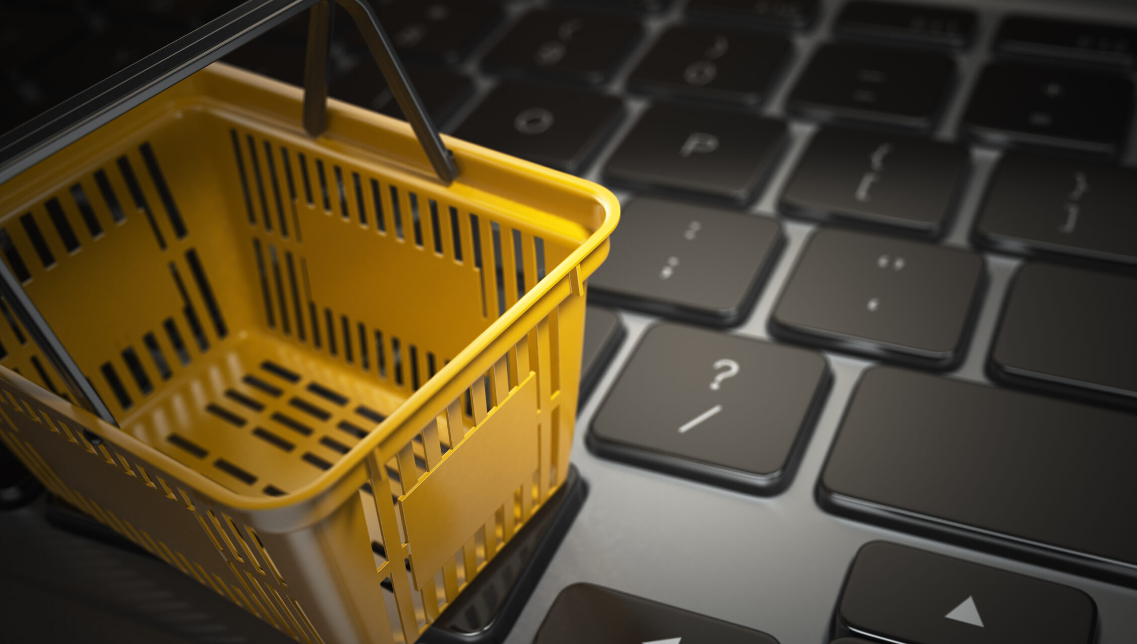 E-commerce, online shopping, internet purchases concept.  Yellow shopping basket on computer laptop keyboard, 3d illustration